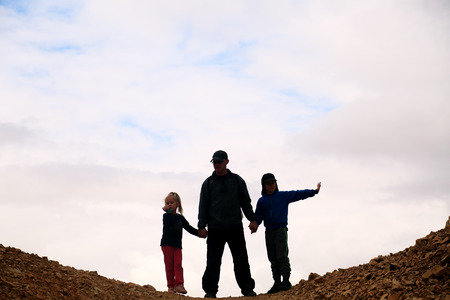 father hiking with two kidsの写真素材