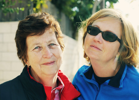 Outdoors portrait of beautiful senior woman and her adult daughterの写真素材