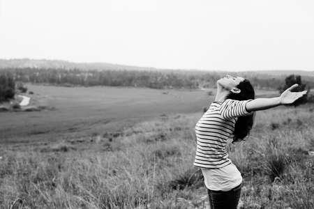 Woman with open arms standing outdoorsの写真素材