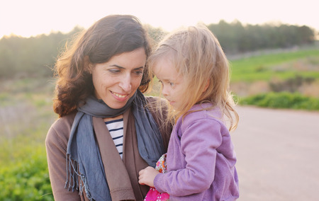 outdoor portrait of a beautiful middle aged mother and daughterの写真素材