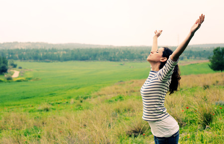 Woman with open arms standing outdoorsの写真素材