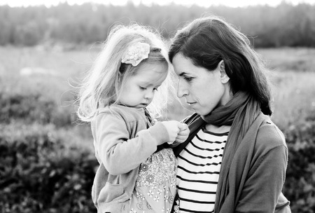 outdoor portrait of a beautiful middle aged mother and daughterの写真素材