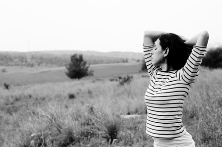 Woman with open arms standing outdoorsの写真素材