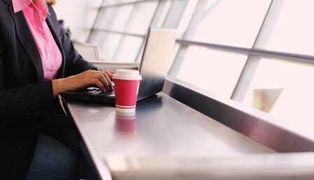 elegant business woman using devices in airportの写真素材
