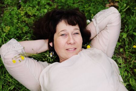 Portrait of beautiful real 45 years old woman in the parkの写真素材