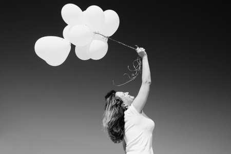 Beautiful redhead woman holding pink balloonsの写真素材