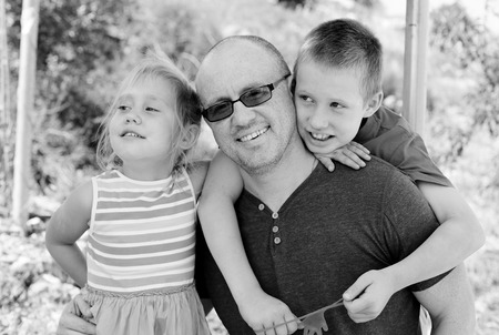 Portrait of father with two kids outdoorsの写真素材