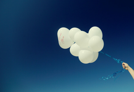white balloons on the background of blue skyの写真素材