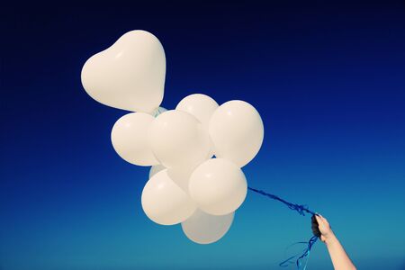 white balloons on the background of blue skyの写真素材