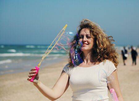 Beautiful redhead woman holding bubbleの写真素材