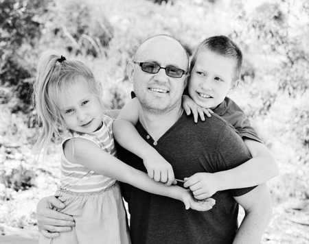 Portrait of father with two kids outdoorsの写真素材