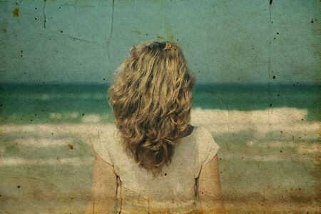 Beautiful redhead woman standing on the beach.の写真素材