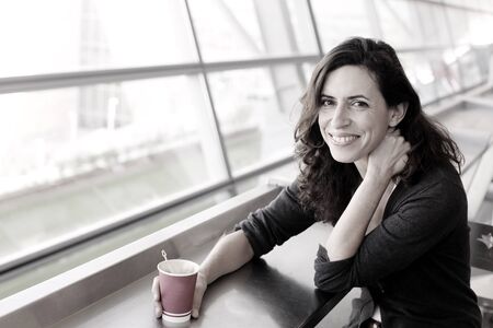 Portrait of beautiful 40 years old woman holding cup of coffeeの写真素材