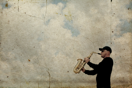 Saxophonist playing on saxophone outdoor. Old style photo.の写真素材