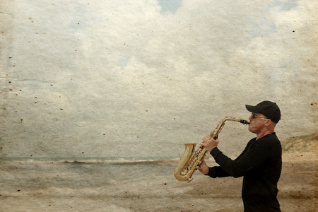 Saxophonist playing on saxophone outdoor. Old style photo.の写真素材