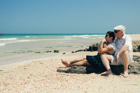 senior couple sitting on the beachの写真素材