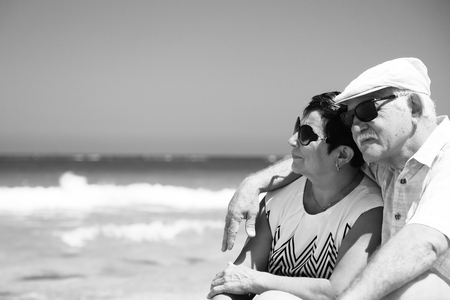 senior couple sitting on the beachの写真素材