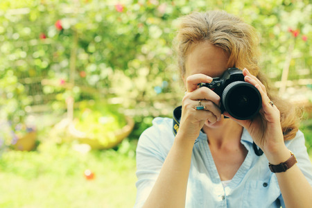 Woman with camera outdoorsの写真素材