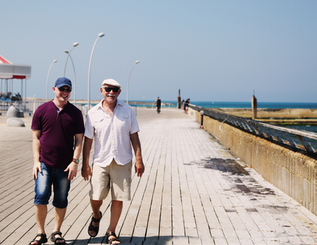 adult son and father walking together near the seaの写真素材