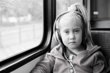 5 years old girl sitting in the train near the windowの写真素材