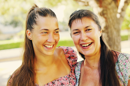 Portrait of beautiful 45 years old mother with young daughterの写真素材