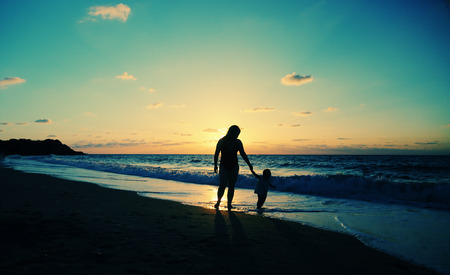 Portrait of happy loving mother and her baby at the beachの写真素材