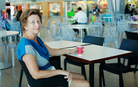 Portrait of beautiful 70 years old woman sitting in the airportの写真素材