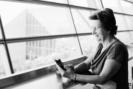 Portrait of beautiful 70 years old woman sitting in the airportの写真素材