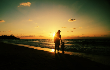 Portrait of happy loving mother and her baby at the beachの写真素材