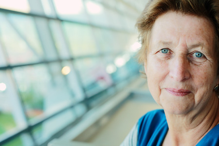 Portrait of beautiful 70 years old woman sitting in the airportの写真素材
