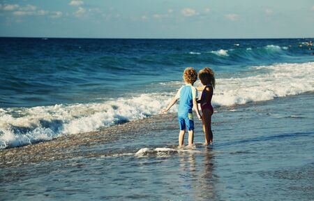 kids playing on the beach at sunsetの写真素材