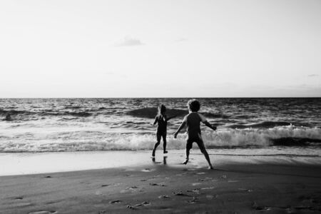kids playing on the beach at sunset