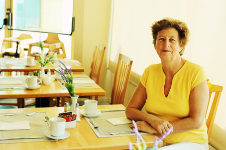 Portrait of beautiful 70 years old woman drinking morning coffeeの写真素材