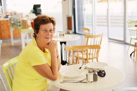 Portrait of beautiful 70 years old woman drinking morning coffeeの写真素材