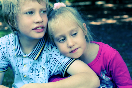 Portrait of happy 5 years old girl with her autistic 8 years old brotherの写真素材