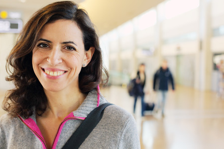 Portrait of beautiful 40 years old woman standing in airport. Travel content.の写真素材