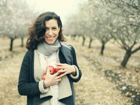 Outdoor portrait of 40 years old woman holding red applesの写真素材