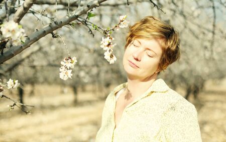 Happy woman in spring blossom park. soft backlight