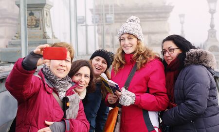 Outdoor portrait of five friends taking selfie with a smartphoneの写真素材
