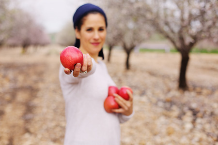 Outdoor portrait of 40 years old woman holding red applesの写真素材