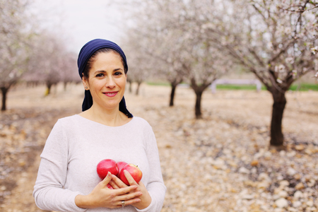 Outdoor portrait of 40 years old woman holding red applesの写真素材