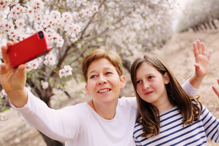 Happy mother and daughter in spring blossom park. Mother day.の写真素材