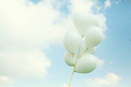 white balloons on blue sky backgroundの写真素材