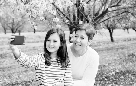 Happy mother and daughter in spring blossom park. Mother day.の写真素材