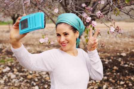 Outdoor portrait of 40 years old woman making selfieの写真素材