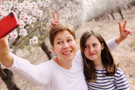 Happy mother and daughter in spring blossom park. Mother day.の写真素材