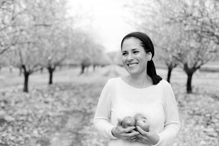 Outdoor portrait of 40 years old woman holding red applesの写真素材