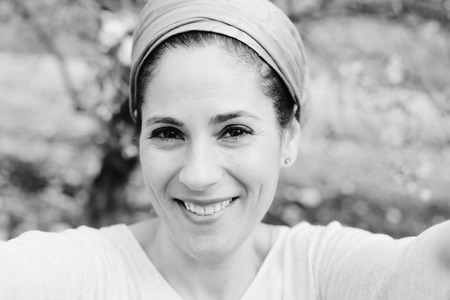 Outdoor portrait of 40 years old woman making selfie