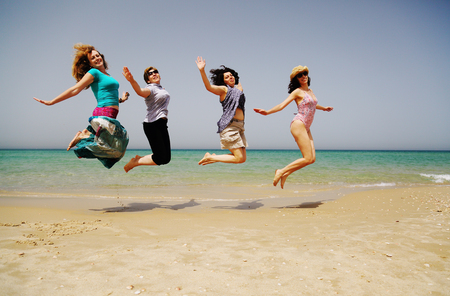 Portrait of four  40 years old women walking on seasideの写真素材