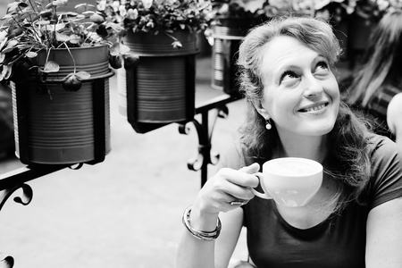 Portrait of beautiful 40 years old woman sitting in outdoor cafeの写真素材